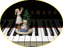 ピアノの鍵盤とクリスマスツリーを飾る子供たちの置物の写真